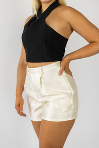 Shorts in satin twill fabric Dressy shorts that feature side pockets for comfort, belt loop, front pleat detail, and button with zipper closure at front. Ivory